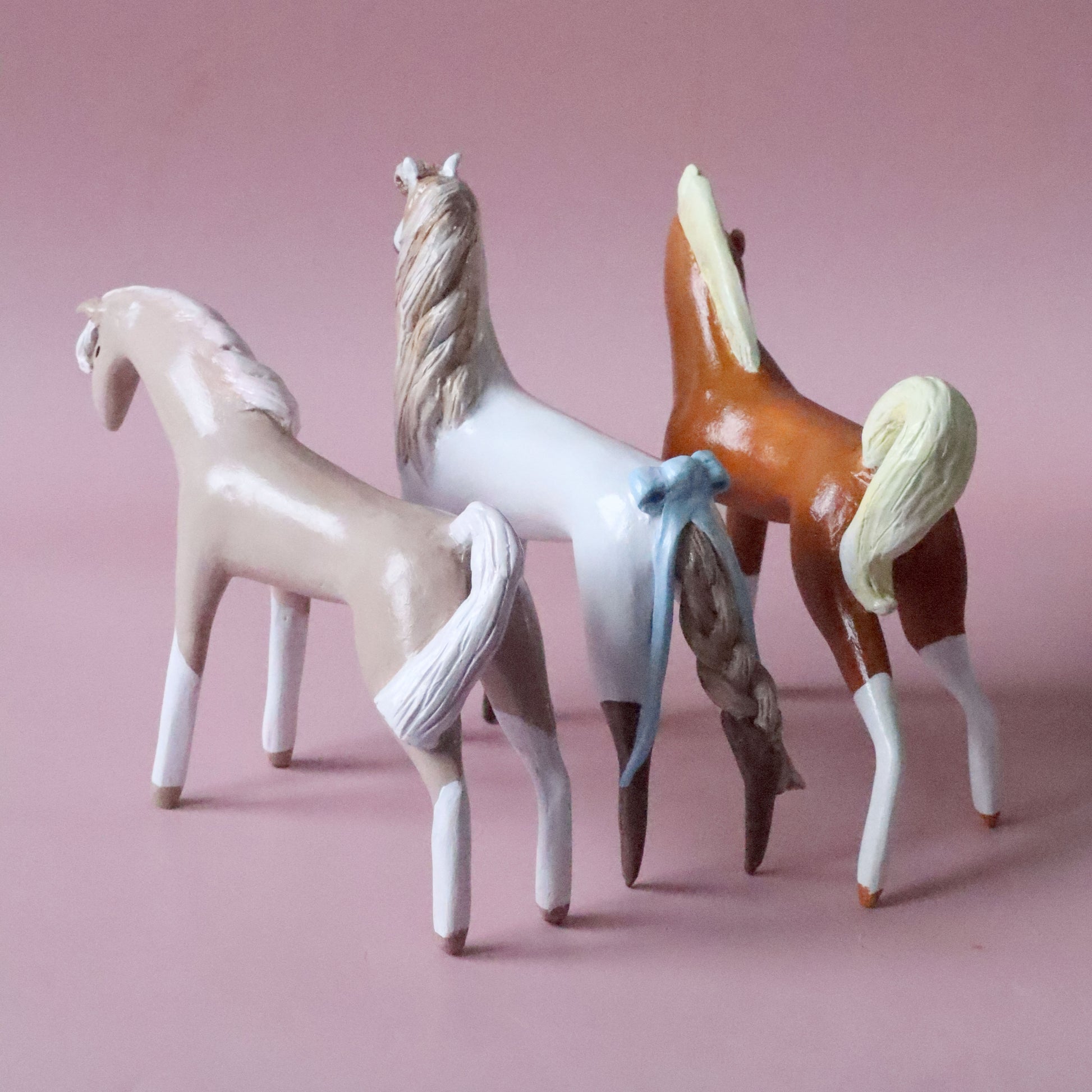 Three horse figurines in beige, white and red 